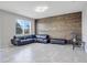 Bright living room with rustic wood accent wall, tile floors, and a comfortable leather sectional sofa at 624 Sardinia Circle, Davenport, FL 33837