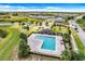 Aerial view of community pool surrounded by lounge area, playground, and well-manicured landscaping at 624 Sardinia Circle, Davenport, FL 33837