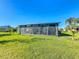 Enclosed porch area with ample seating, a hot tub, and views of the backyard and tropical landscaping at 657 Shorehaven Dr, Poinciana, FL 34759