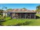 View of the covered and screened back porch, featuring curtains and offering outdoor living with comfortable seating and a hot tub at 657 Shorehaven Dr, Poinciana, FL 34759