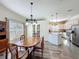 This dining room features wood flooring, a modern chandelier and an adjacent, well-equipped kitchen at 657 Shorehaven Dr, Poinciana, FL 34759