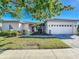 Charming single-story home featuring a manicured lawn, lush landscaping and a brick-paved driveway at 657 Shorehaven Dr, Poinciana, FL 34759