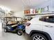 Garage featuring a golf cart and car, with overhead storage shelves for organization at 657 Shorehaven Dr, Poinciana, FL 34759