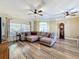 Large living room with hardwood floors, an elegant ceiling fan, and neutral-tone walls at 657 Shorehaven Dr, Poinciana, FL 34759