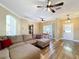 Cozy living room showcasing hardwood flooring, a ceiling fan, and ample natural light at 657 Shorehaven Dr, Poinciana, FL 34759