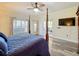 Spacious main bedroom with decorative ceiling fan, wood floors and sliding glass doors to the patio at 657 Shorehaven Dr, Poinciana, FL 34759