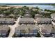 Community aerial showcasing rows of townhomes with scenic water views, lush greenery, and convenient parking at 6659 Times Square Ave 38-103 # Orlando, Orlando, FL 32835