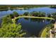 Scenic aerial view showcasing a serene lake with a fountain, surrounded by lush greenery and a paved walkway at 6659 Times Square Ave 38-103 # Orlando, Orlando, FL 32835