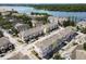 Aerial of colorful townhomes surrounding a lake and landscaped with trees offering an inviting residential setting at 6659 Times Square Ave 38-103 # Orlando, Orlando, FL 32835