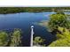 Scenic aerial view of a lake with a gazebo-topped dock, set against a backdrop of lush greenery and condos at 6659 Times Square Ave 38-103 # Orlando, Orlando, FL 32835