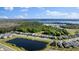 Aerial view capturing the lake and a well-planned residential neighborhood at 7465 Wing Span Way, Harmony, FL 34773