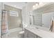 Bright bathroom featuring a bathtub, shower, vanity, and large mirror at 7465 Wing Span Way, Harmony, FL 34773