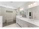 Stylish bathroom boasts a frameless glass shower, dual sinks, and modern fixtures, exuding elegance and functionality at 7465 Wing Span Way, Harmony, FL 34773