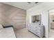 Stylish bedroom featuring unique accent wall, neutral-toned furniture, and adjacent bathroom at 7465 Wing Span Way, Harmony, FL 34773