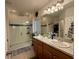 Well-lit bathroom with double sinks, a glass-enclosed shower, and tile flooring at 813 Marcel Loop, Davenport, FL 33837