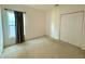 A simple bedroom with carpeted floors, a window with curtains, and a closet with white doors at 813 Marcel Loop, Davenport, FL 33837