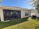 Exterior of the house showcasing the screened patio with a view of the backyard and well-maintained lawn at 813 Marcel Loop, Davenport, FL 33837