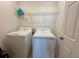 A well-lit laundry room with a washer, dryer and a shelf at 813 Marcel Loop, Davenport, FL 33837