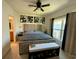 Bright main bedroom featuring a tufted headboard, ceiling fan, and ensuite bathroom at 813 Marcel Loop, Davenport, FL 33837