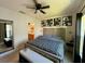 Spacious main bedroom featuring a tufted headboard, ceiling fan, and ensuite bathroom at 813 Marcel Loop, Davenport, FL 33837