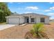Charming single-story home featuring a two-car garage, fresh landscaping, and a well-manicured lawn at 101 Sail Way, Kissimmee, FL 34759