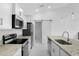 Modern kitchen featuring stainless steel appliances, granite countertops, and a sliding barn door at 101 Sail Way, Kissimmee, FL 34759