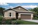 Charming single-Gathering home featuring a two-car garage, manicured landscaping, and stone accents at 1019 Wisteria Way, Dundee, FL 33838