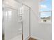 Bathroom featuring a glass shower door, wood-look flooring, and a bright window at 1027 Wisteria Way, Dundee, FL 33838