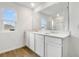 Bathroom featuring a double vanity, white cabinets, and a large mirror above the sinks at 1027 Wisteria Way, Dundee, FL 33838