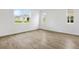 Bright, empty bedroom with wood-look floors and multiple windows at 1027 Wisteria Way, Dundee, FL 33838