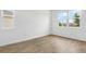 Bright, empty bedroom with wood-look floors and a large window at 1027 Wisteria Way, Dundee, FL 33838