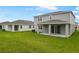 Rear exterior showcasing a covered patio and well-maintained lawn at 1027 Wisteria Way, Dundee, FL 33838