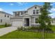 Charming two-story home with stone accents, landscaped yard, and attached two-car garage at 1027 Wisteria Way, Dundee, FL 33838