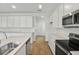 Bright kitchen features white cabinets, a center island with sink, and stainless steel appliances at 1027 Wisteria Way, Dundee, FL 33838