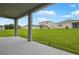 Covered patio offering ample space for outdoor living and entertaining with view of the spacious backyard at 1027 Wisteria Way, Dundee, FL 33838
