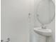 Clean powder room features pedestal sink, round mirror, and chrome fixtures at 1027 Wisteria Way, Dundee, FL 33838
