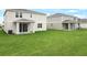 A house backyard with manicured lawn and covered patios with sliding glass doors at 1031 Wisteria Way, Dundee, FL 33838
