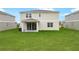 A house backyard with manicured lawn and a covered patio with sliding glass doors at 1031 Wisteria Way, Dundee, FL 33838
