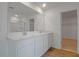 Bright bathroom showcasing double sinks with white cabinetry and a large mirror at 1031 Wisteria Way, Dundee, FL 33838