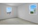 A bright bedroom with neutral carpeting and a window overlooking a neighbor's house at 1031 Wisteria Way, Dundee, FL 33838