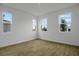 Bright bedroom with wood-look flooring, white walls, and multiple windows showcasing the neighborhood at 1031 Wisteria Way, Dundee, FL 33838
