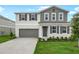 Charming two-story home featuring gray and white colors, a landscaped yard, and a two car garage at 1031 Wisteria Way, Dundee, FL 33838