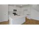 Bright kitchen featuring white cabinets, stainless steel appliances, and an island with white countertop at 1031 Wisteria Way, Dundee, FL 33838