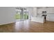 Open-concept living space with wood-look flooring, sliding glass doors, and a view into the bright kitchen at 1031 Wisteria Way, Dundee, FL 33838