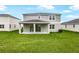 Expansive backyard features lush grass, a covered patio and a view of the home's exterior at 1035 Wisteria Way, Dundee, FL 33838
