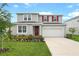 Charming two-story home with a well-manicured lawn and colorful flower beds at 1035 Wisteria Way, Dundee, FL 33838