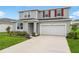 Charming two-story home with a well-manicured lawn and colorful flower beds at 1035 Wisteria Way, Dundee, FL 33838