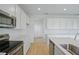 Bright kitchen featuring stainless steel appliances and white cabinetry at 1035 Wisteria Way, Dundee, FL 33838
