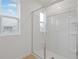 Modern bathroom shower with glass door and a window at 1035 Wisteria Way, Dundee, FL 33838