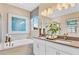 Elegant bathroom featuring dual sinks, a soaking tub, and modern fixtures with bright natural light at 1039 Wisteria Way, Dundee, FL 33838